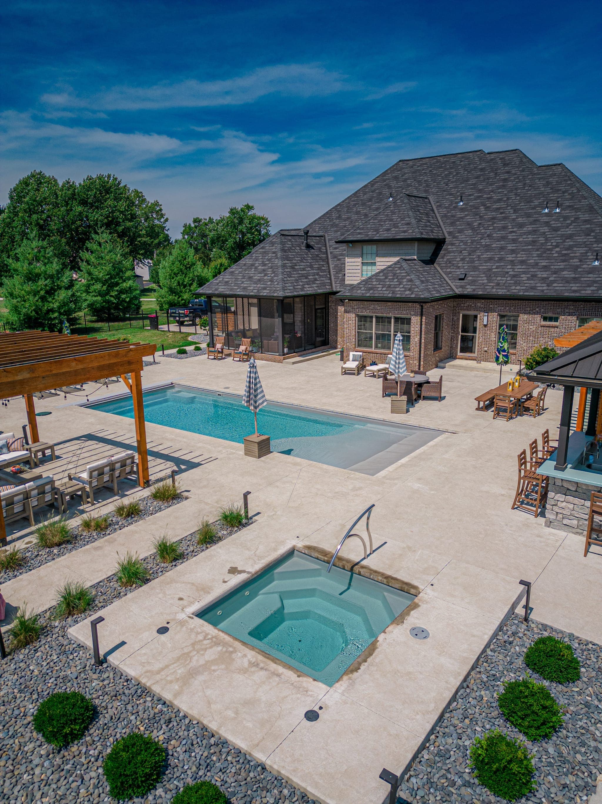 Pool and spa with water cascade feature and ambient lighting
