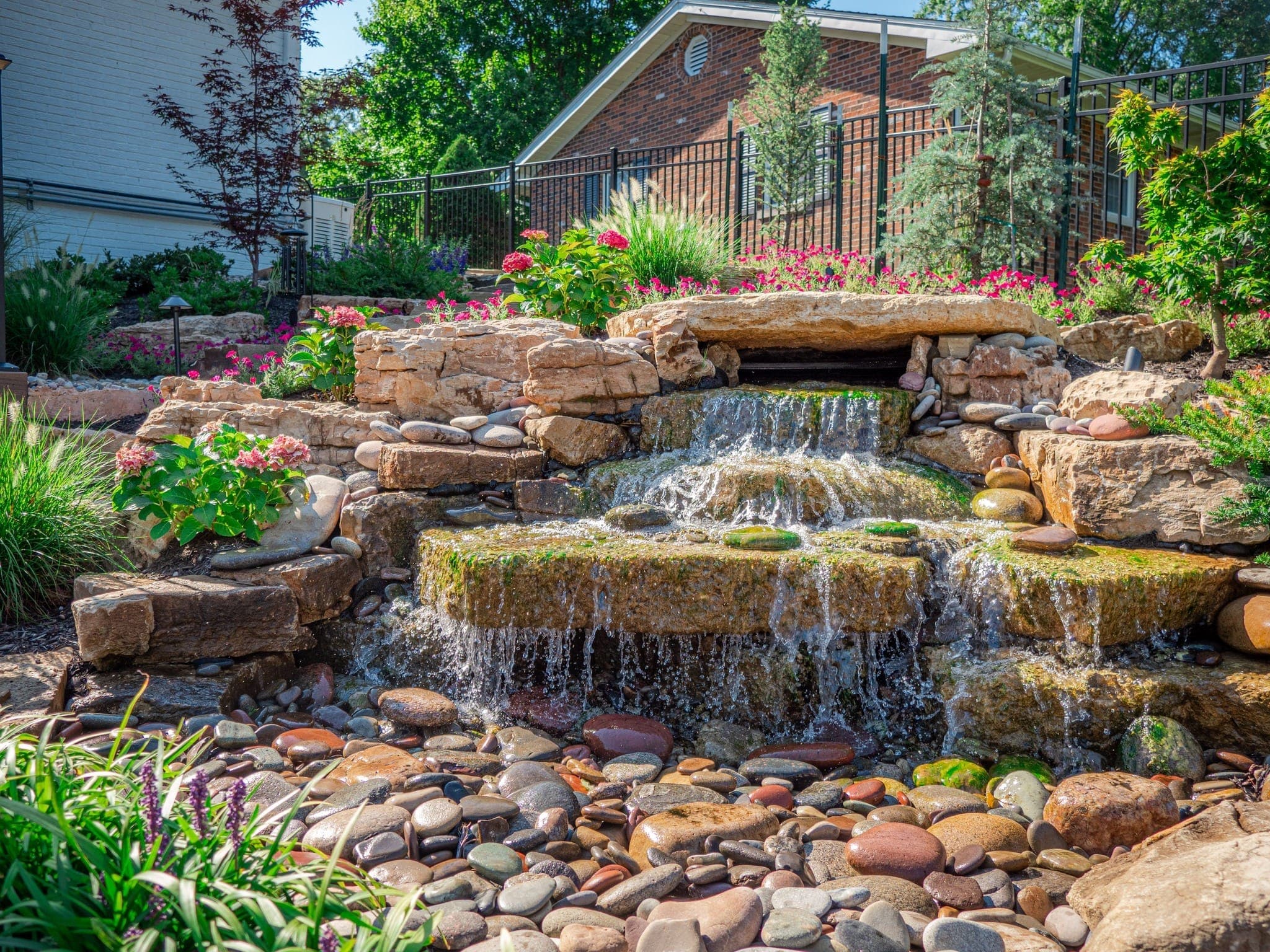 Custom stone waterfall and water feature with lush landscaping