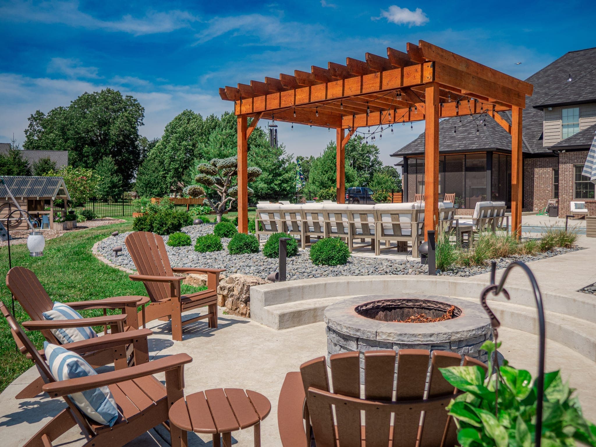 Outdoor fire pit area with pergola and comfortable seating