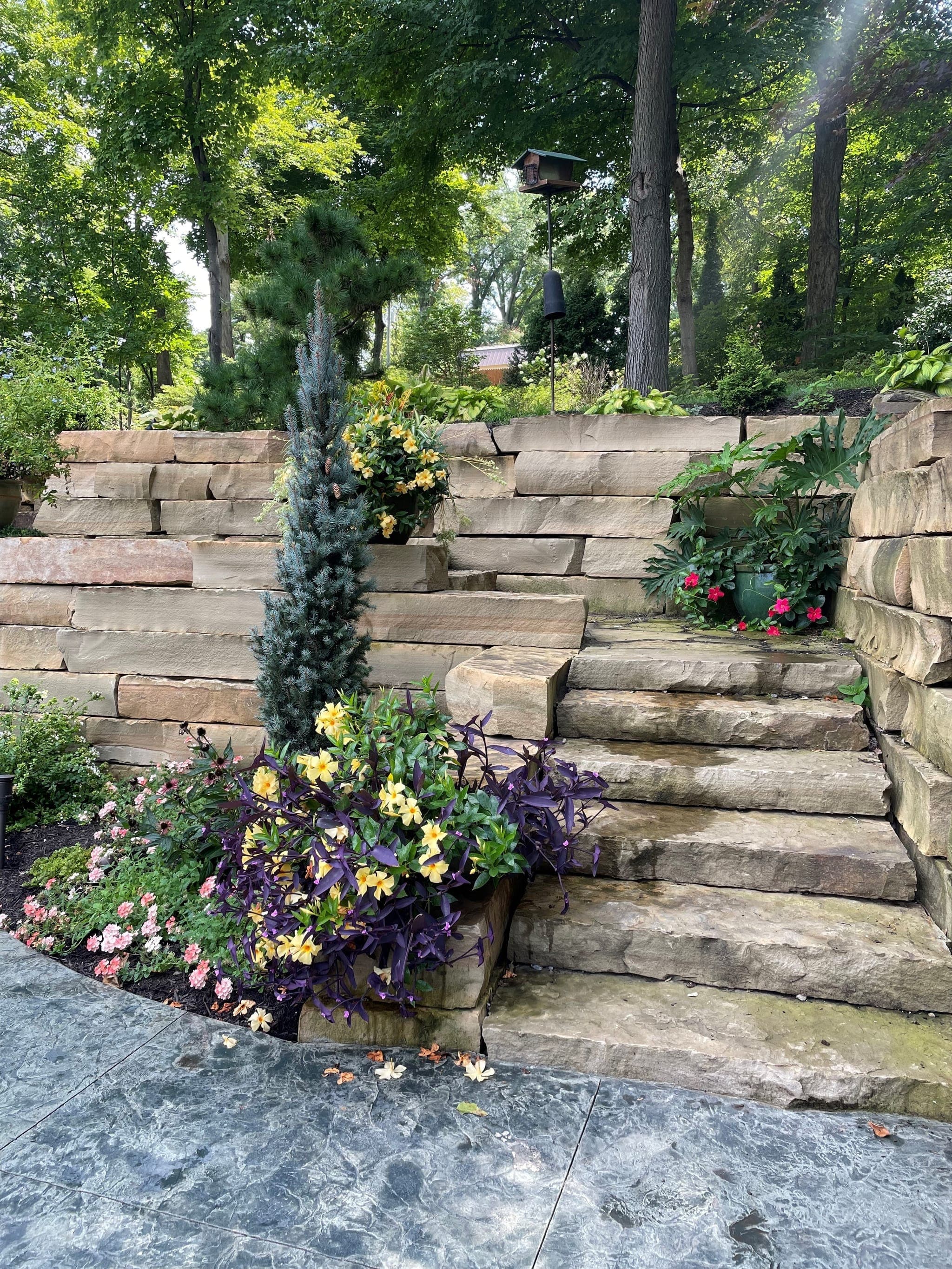 Professionally built stone retaining wall with landscaping